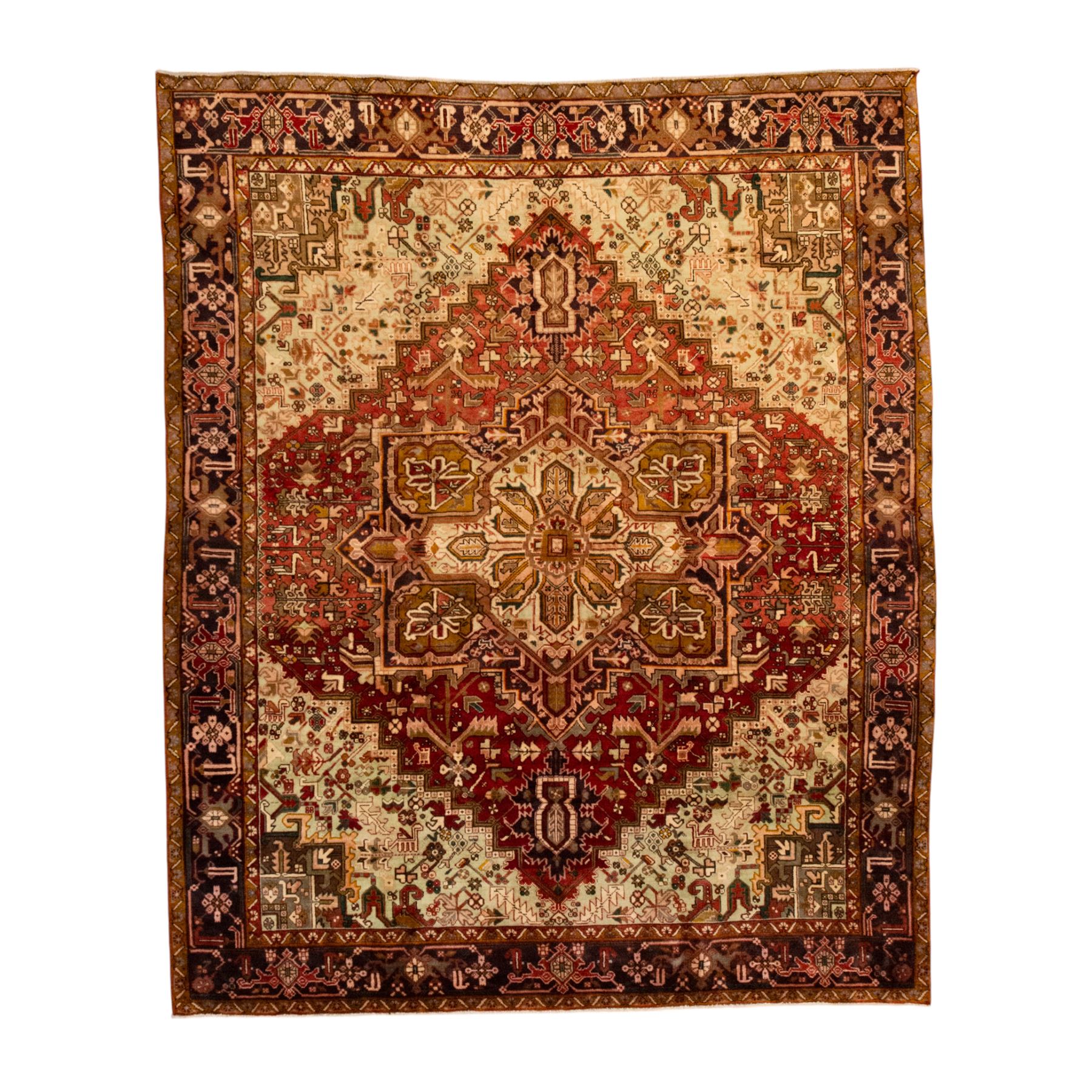 Northwestern Persian Heriz carpet, crimson ground and soft green field, with bold terracotta stepped medallion with angular spandrels and geometric motifs within a broad palmette and vine border 