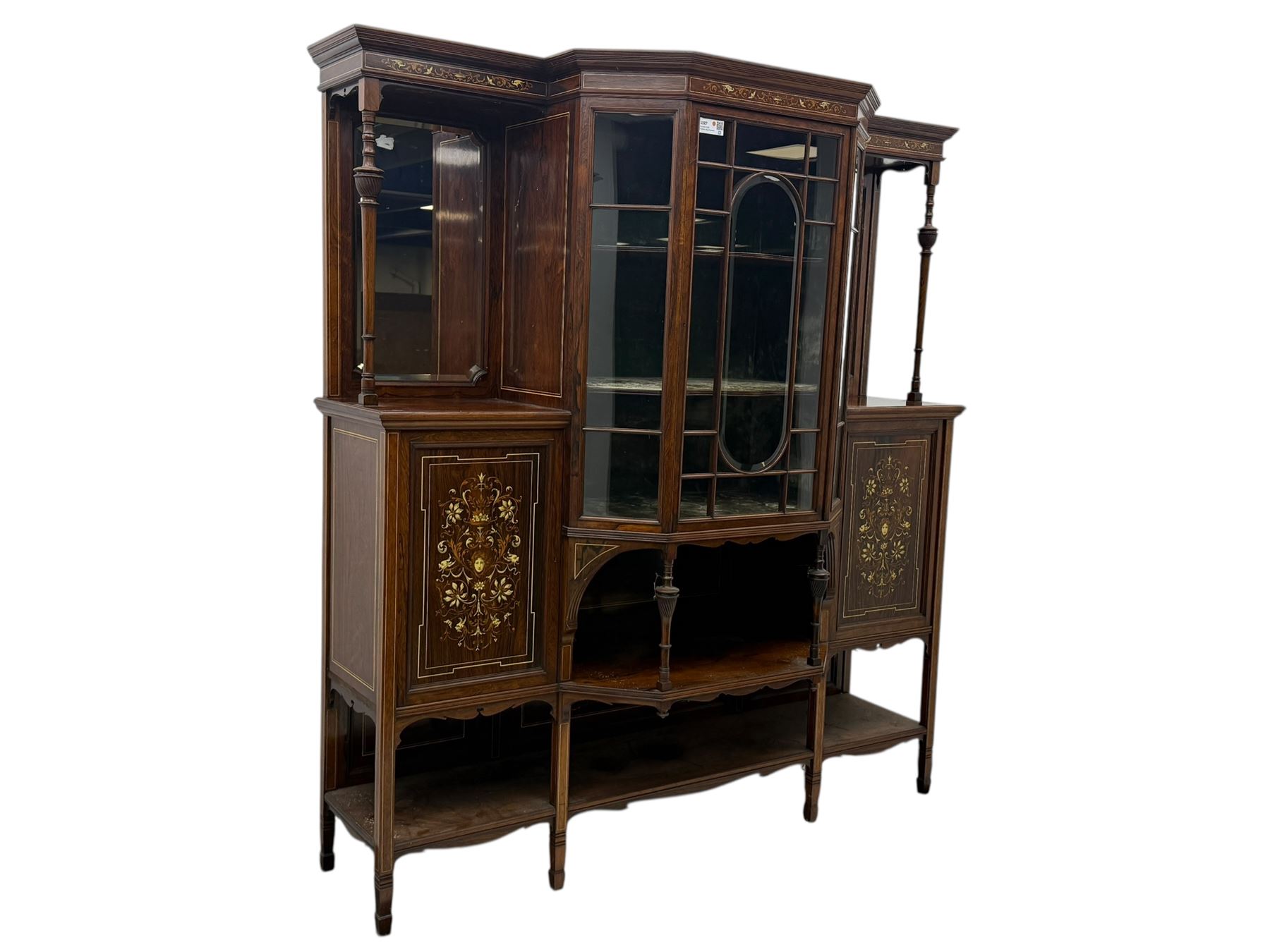 Victorian hardwood and inlaid display cabinet, central breakfront glazed display with astragal glazing and mirror back, flanked by mirrored alcoves with turned supports, below foliate and scrolling marquetry panels enclosing cupboard doors, shaped open shelves with turned supports beneath, on tapered and spade feet