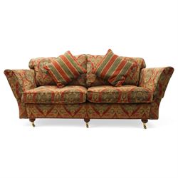 Duresta - traditional shape two-seat sofa with out-swept arms, upholstered in crimson ground fabric decorated with palmettes and foliate motifs with matching loose and scatter cushions, raised on compressed bun feet with brass cups and castors