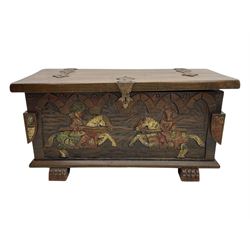 Mid-20th century carved hardwood chest, the rectangular hinged top with decorative strap hinges, the front and sides deeply carved with medieval-style jousting knights, heraldic shields, and architectural elements, raised on shaped block feet