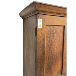 The North of England School Furnishing Company Limited Darlington - early 20th century oak school cupboard, projecting moulded cornice over two panelled doors, fitted with shelves, on chamfered plinth base 