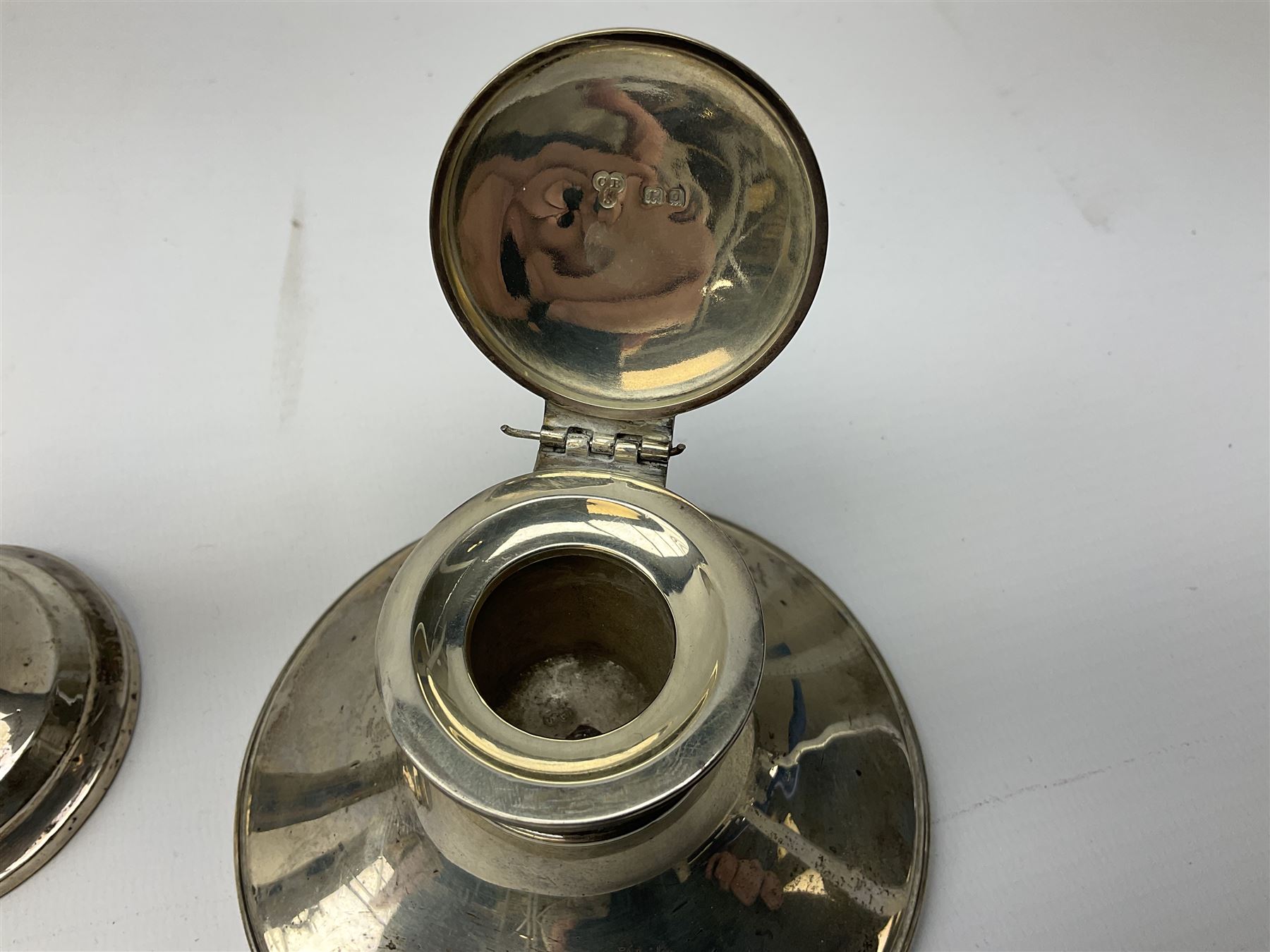 1920's silver mounted capstan inkwell, hallmarked Charles Boyton & Son Ltd, London 1929, together with an early 20th century silver mounted dwarf candlestick, hallmarked A J Pepper & Co, Birmingham 1918