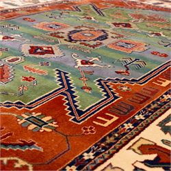Late 20th century, French-made Caucasian design rug, woven with a dense pile, field decorated with a bold central stepped medallion flanked by stylized tribal and geometric motifs, borders of angular foliate designs in a palette of terracotta red with cotton fringe ends