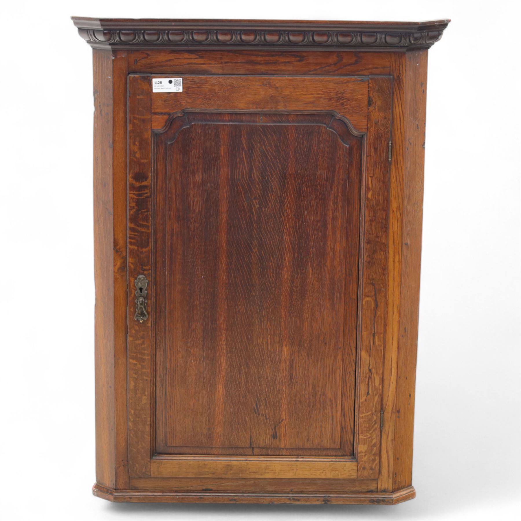19th century oak wall hanging corner cupboard, moulded cornice above a panelled door enclosing shaped interior shelves, finished in green paint to the backboards