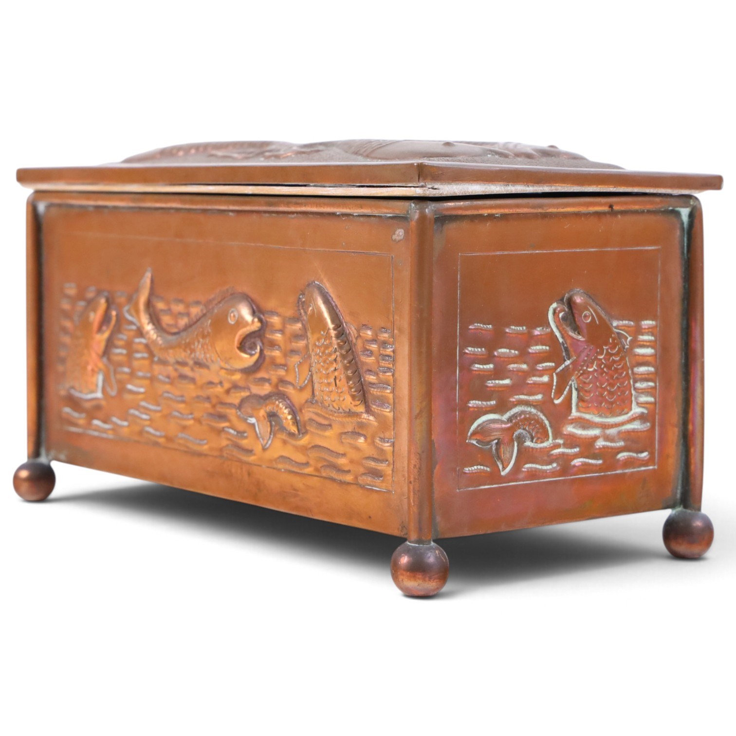 Art and Crafts copper and brass hammered casket, of rectangular form with repoussé decoration of dolphins, in the manner of  John Pearson, H10cm L19cm