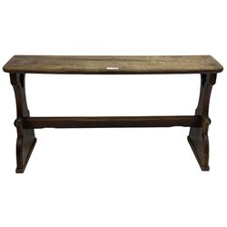 Late Victorian ecclesiastical pitch pine side table, rectangular bow-front top, on shaped end supports pierced with quatrefoils, united by pegged stretcher 