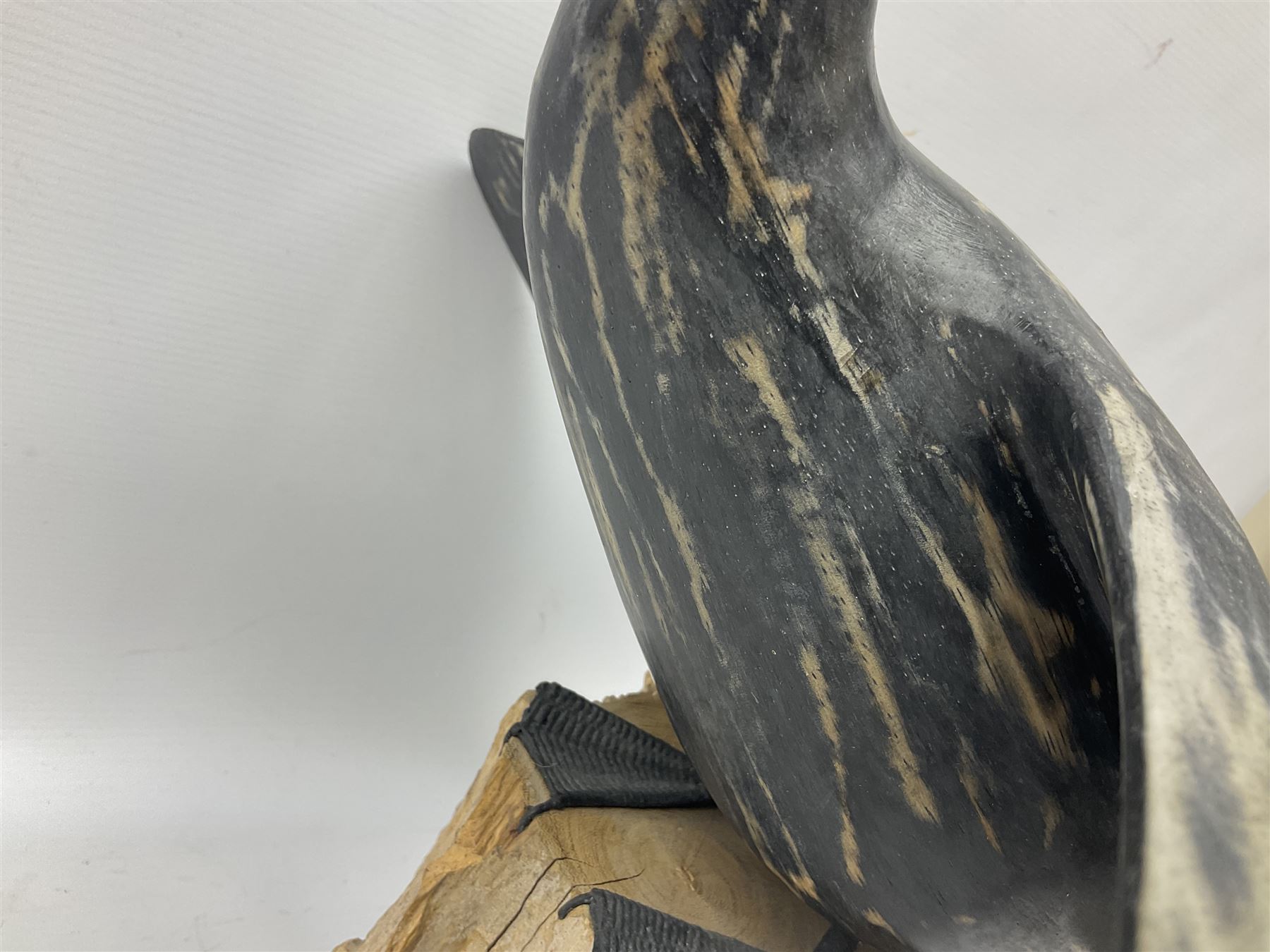 Wooden sculpture of Cormorant aquatic bird on a naturalistic wooden plinth, H46cm