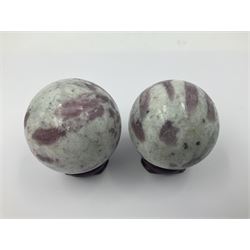 Pair of pink tourmaline spheres, upon carved wooden bases, D5cm