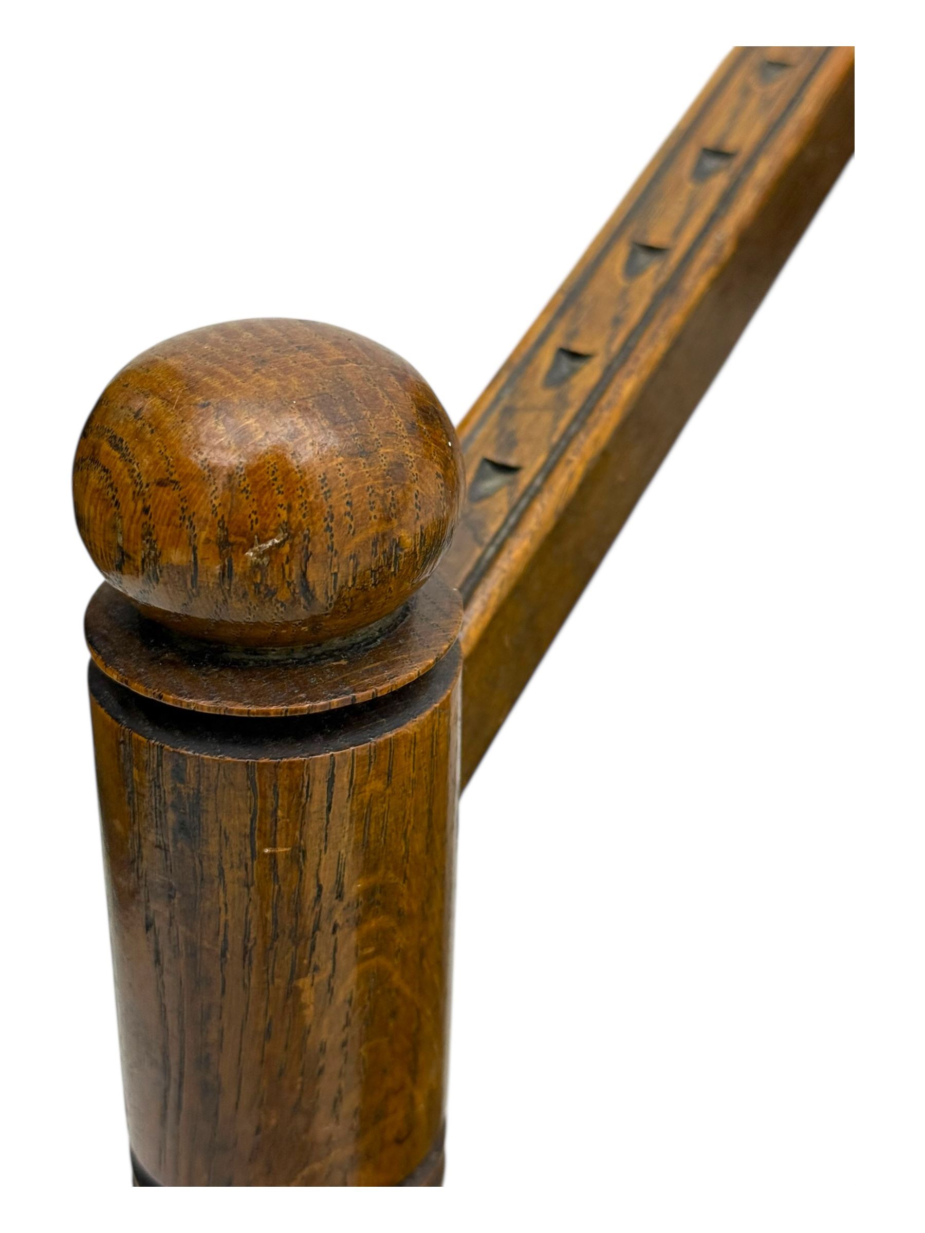 19th century swedish monk's chair, the oak frame with triangular seat and sloped arms, the backrest carved with geometric chipwork and a central pierced medallion 