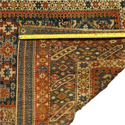 Two antique Caucasian Shirvan rugs, indigo field decorated with horizontal bands of small geometric floral and star motifs within multiple finely drawn borders featuring diamonds, rosettes, and stylized leaves in a palette of madder red, ivory, ochre, and pale blue, with fringe ends, 195x137cm, together with a similar smaller rug, 143x96cm
