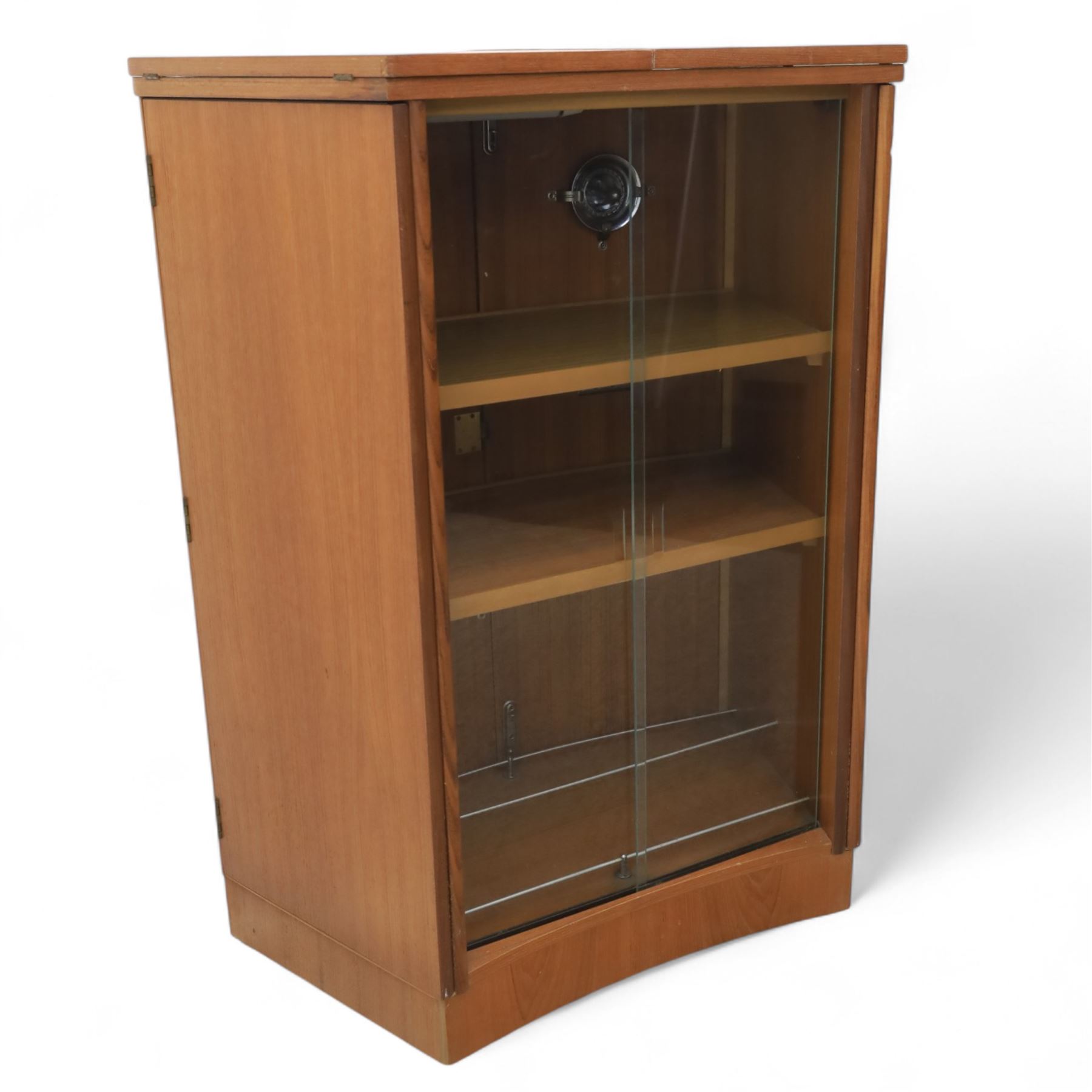 Turnbridge of London - Mid 20th century teak cocktail cabinet, with fold out top extending to 160cm, with twin doors revealing a shelved interior, the back with sliding glazed doors, raised on a recessed plinth base with castors