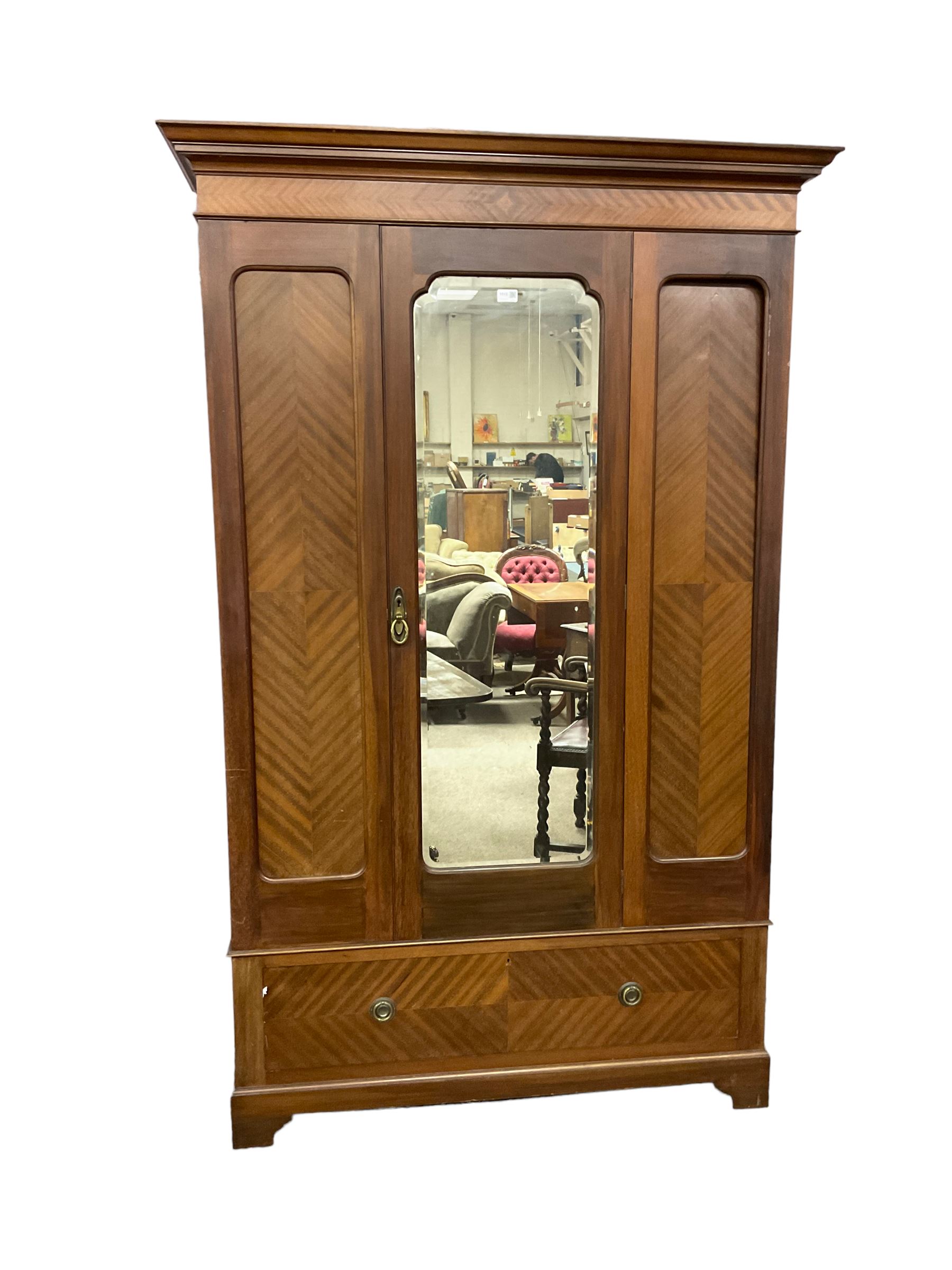 Edwardian mahogany single wardrobe, figured matched veneers to frieze, drawer front and panels, enclosed by bevelled mirror glazed door, base fitted with single drawer, on bracket feet