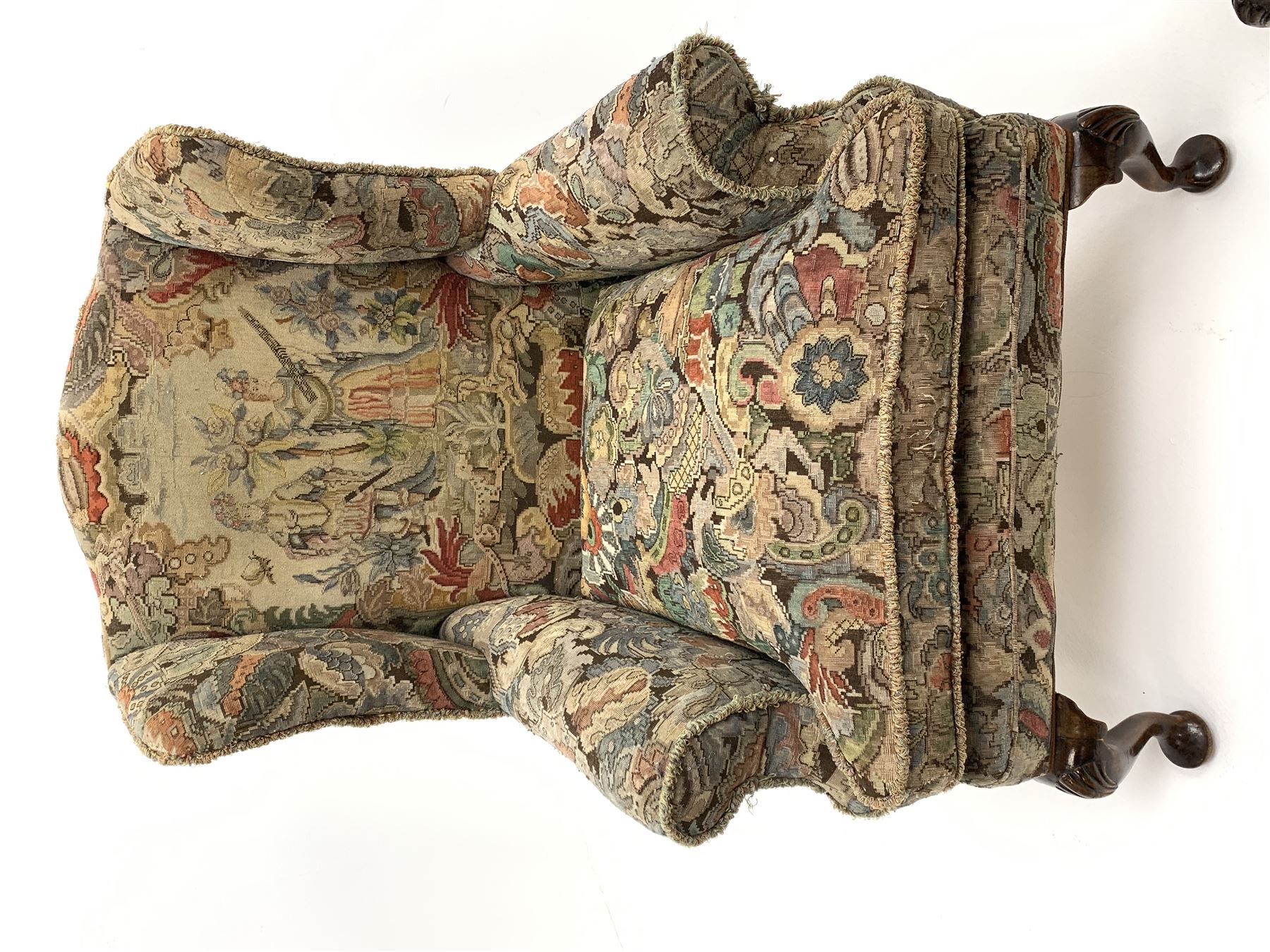 Matched pair early 20th century Queen Anne style wingback armchairs, walnut framed, sprung seats with seat cushions upholstered in needle work cover, shell carved cabriole front feet