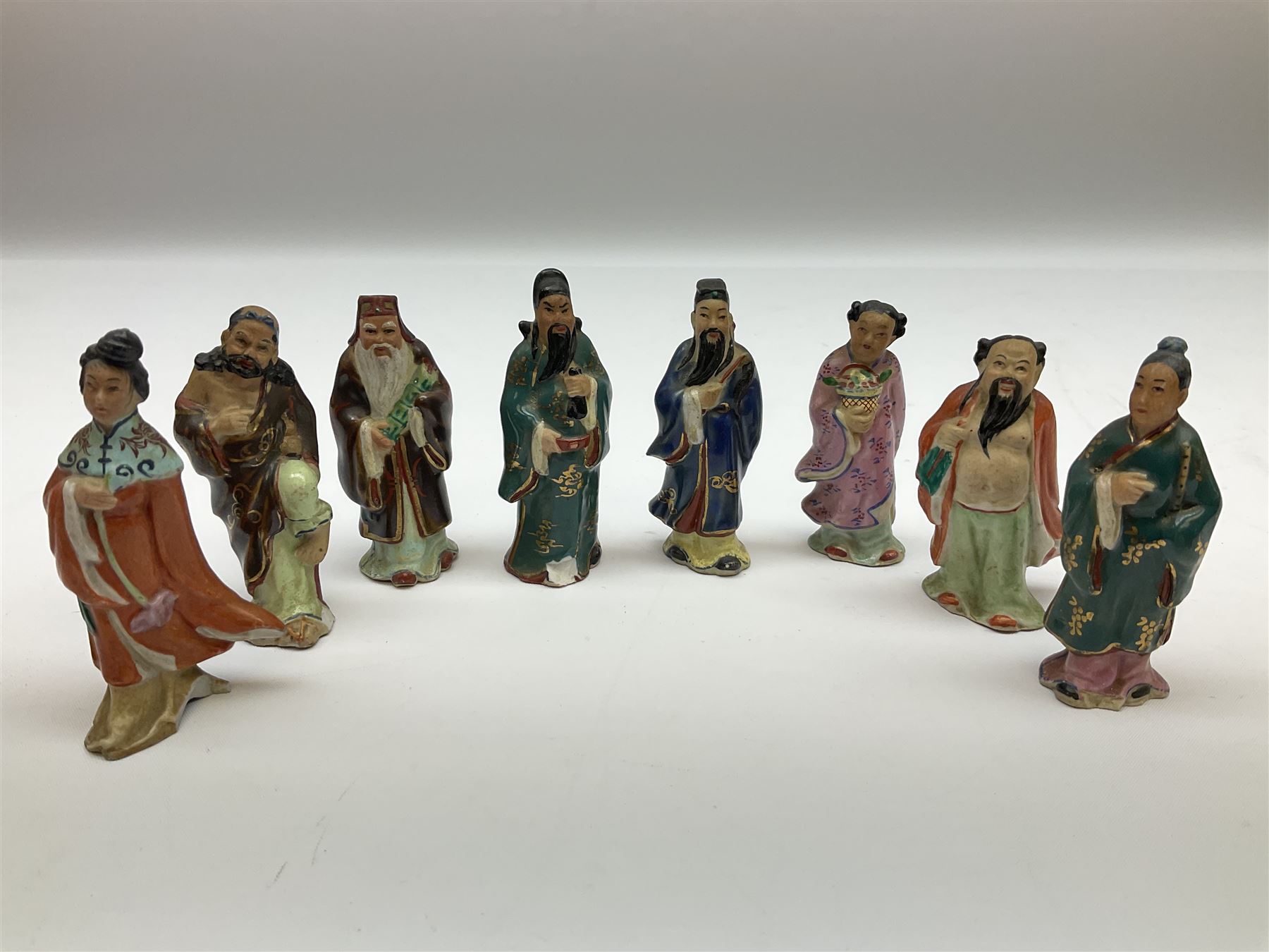 Japanese parquetry puzzle box L12cm; another Japanese puzzle box with marquetry top of Mount Fuji; eleven graduated Chinese figures including immortals; and Chinese figure of a lady standing on a hardwood base next to a horn table (14)