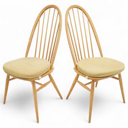 Ercol - light elm set of four Quaker style chairs, high arched backrest with slender spindles, solid wood seat with elasticated strap cushion, on round tapered out swept legs (4)