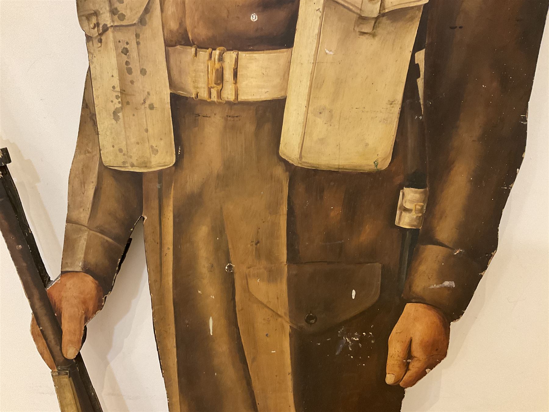 Military Outfitters hand painted life size wooden cut out figure of a WW1 soldier standing at ease holding a gun by his side, marked Stening Signs; hardboard on planked frame H199cm