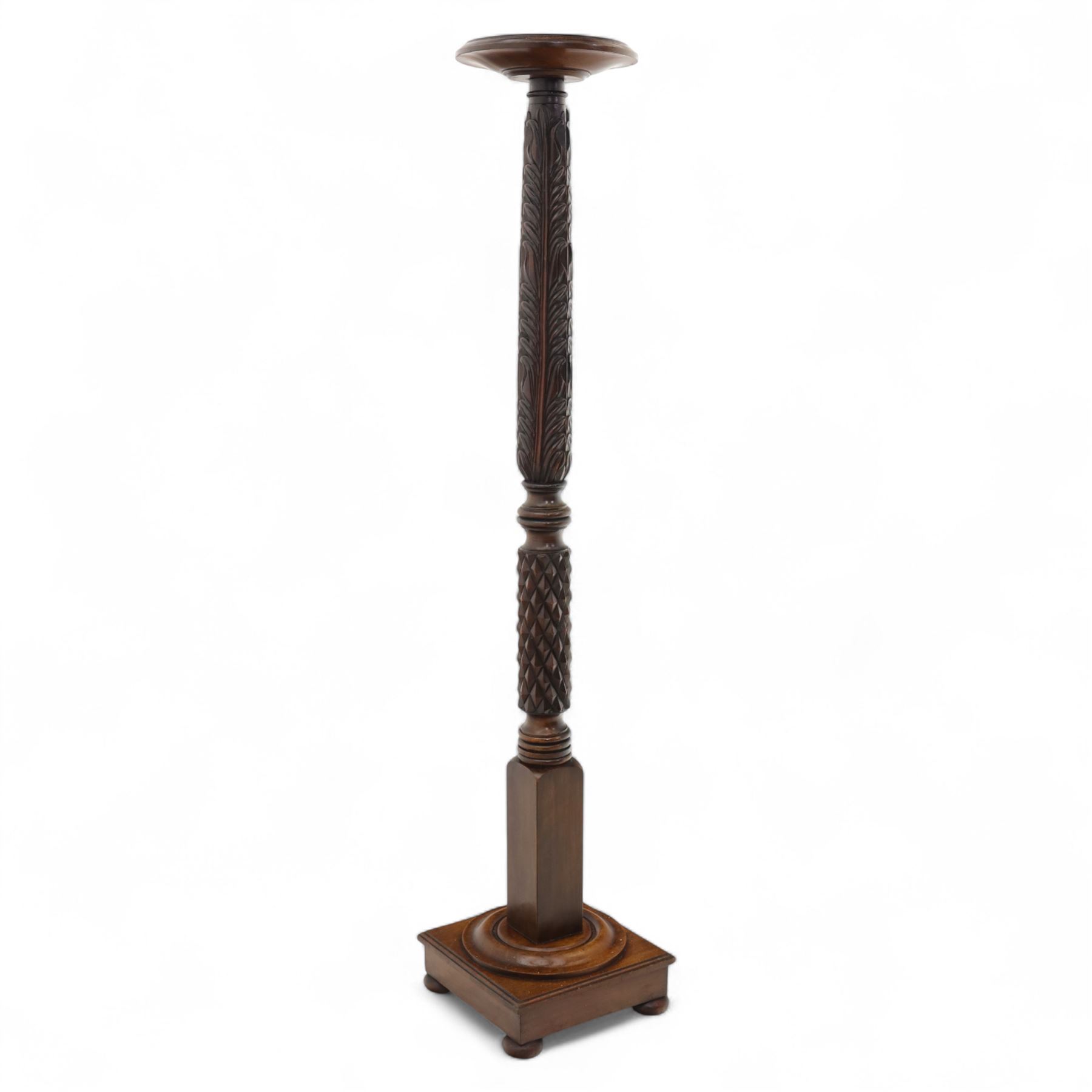 Late 20th century carved mahogany torchère stand, dished top above heavily carved column, with turned elements on moulded square base upon bun feet