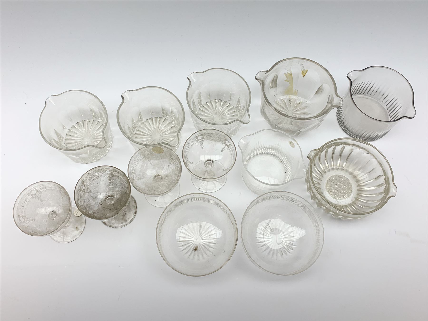 Seven 19th century and later double lip glass rinsers of various design, together with a pair of Edwardian cut glass finger bowls, and four Edwardian champagne glasses with engraved decoration. 