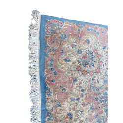 Large Persian design carpet, plain light blue field with floral design central medallion, scrolling foliate spandrels and borders decorated with flower heads