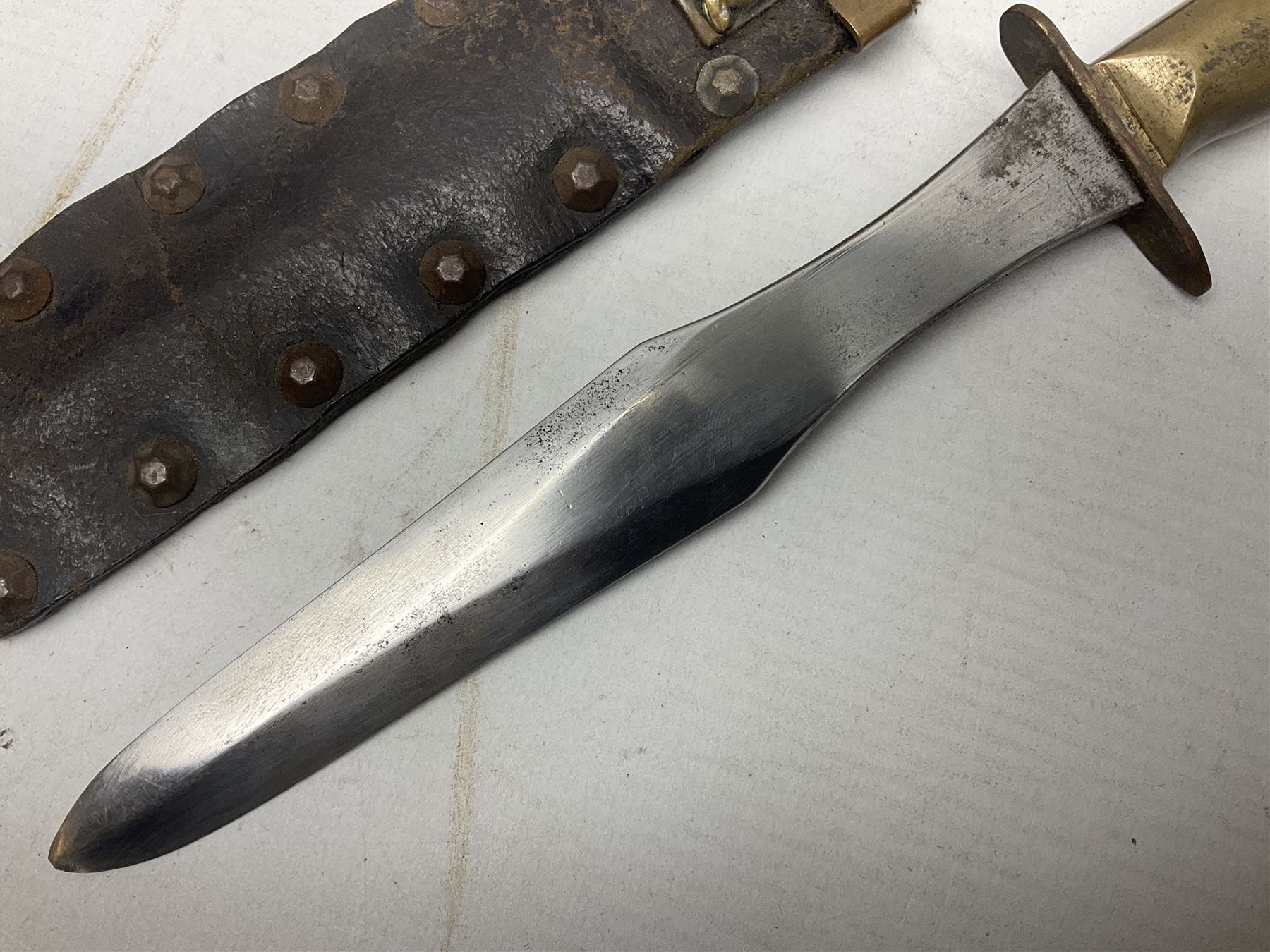 Scratch-built fighting/throwing knife, probably trench art, with 18cm steel spear type blade, plain cross-piece and French Lebel Rifle bayonet grip; in bras mounted studded leather sheath with belt hanger L29.5cm overall