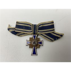 Four German awards - pre-WW2 two-position button hole ribbon for 1914 Iron Cross; WW1 wound badge open back cut-out version with silvered finish; miniature version Mother's Cross with ribbon bow; and The Eastern Medal, officially the Winter Battle in the East 1941–42 Medal (4)