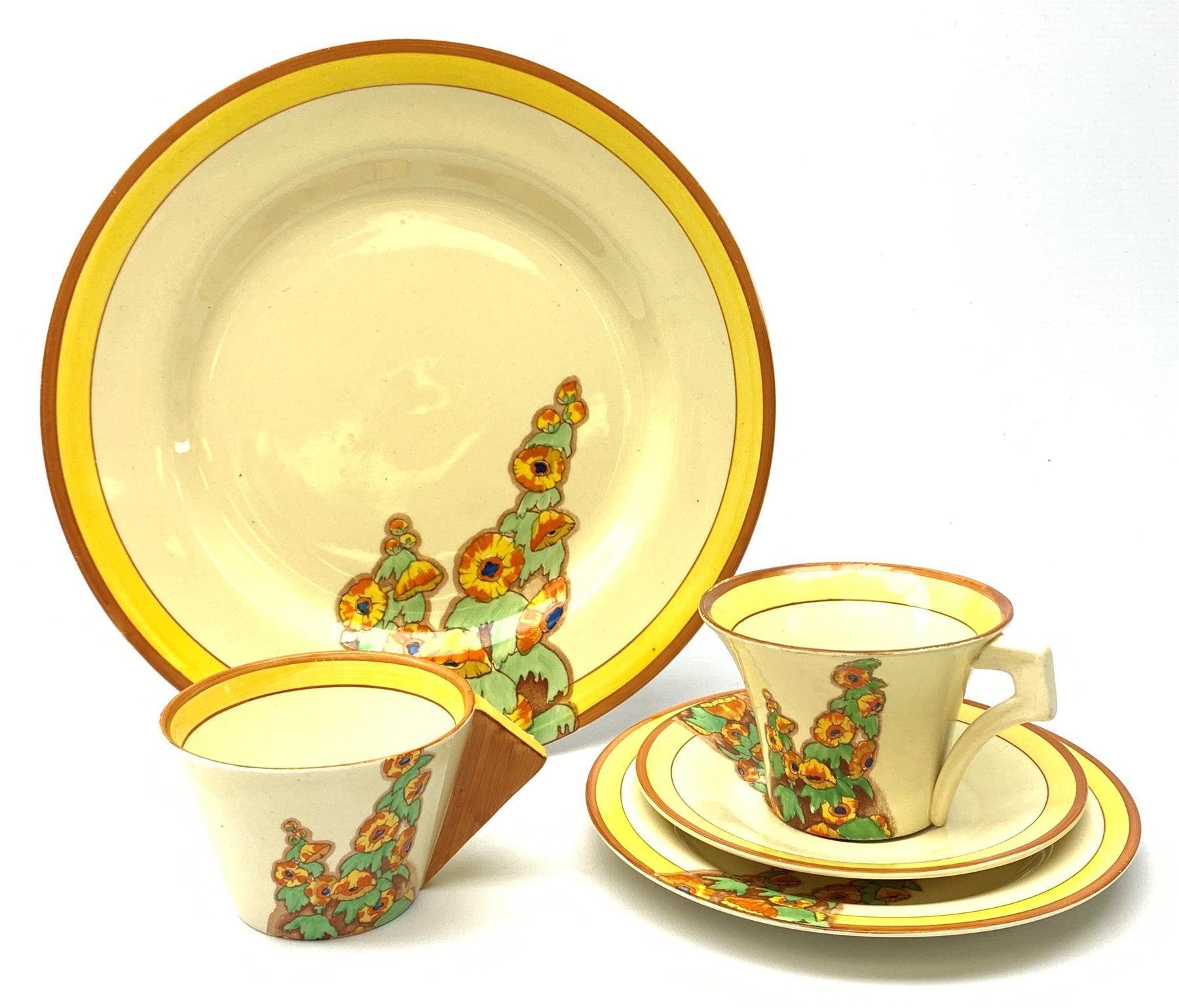 A Clarice Cliff Bizarre by Wilkinson Limited dinner plate, trio and cup in the Sunshine pattern. (5).