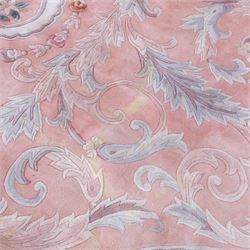 Large late 20th century Aubusson style wool carpet, peach and pastel toned field with central floral medallion enclosing scrolling acanthus and and foliate sprays, surrounding field decorated with further stylized foliage and and floral ornament, within shaped reserves and indigo corner spandrels, enclosed by narrow guard border, cotton fringe ends