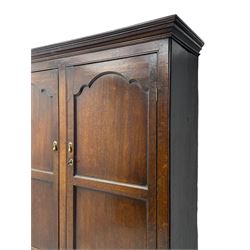 George III oak livery cupboard, projecting moulded cornice over two panelled doors, the upper panels within stepped ogee and arched moulded frame, the interior fitted with a single row of wooden hooks, two short and one long drawers, on bracket and return skirted base 