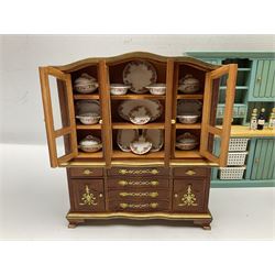 Collection of miniature dolls house furniture, to include display cabinet with pink and white floral dinner service, two serving trolleys with cakes and sweets and two blue painted kitchen dressers, together with miniature dolls house cardboard food packaging and animal figures including dogs and cats, etc