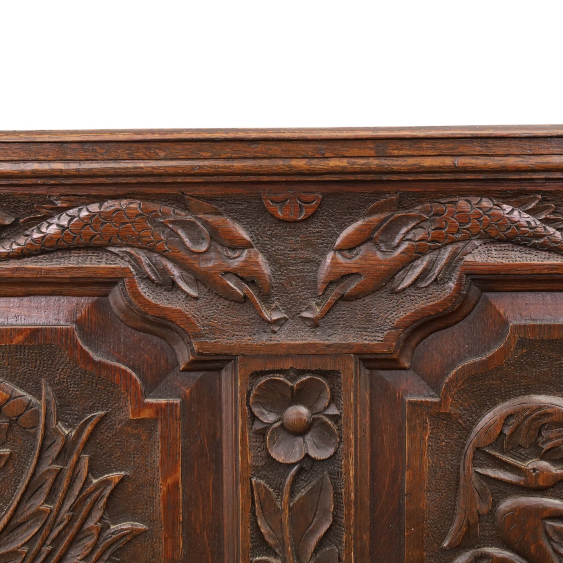 19th century Gothic Revival heavily carved oak settle or hall bench, the high quadruple back with moulded cresting rail over a frieze carved with stylised dolphin and sea creature motifs, the panels decorated with griffin and bird motifs with floral dividing rails, the shaped apron similarly carved with scaly sea beasts, on three cabriole front-supports united by stretchers