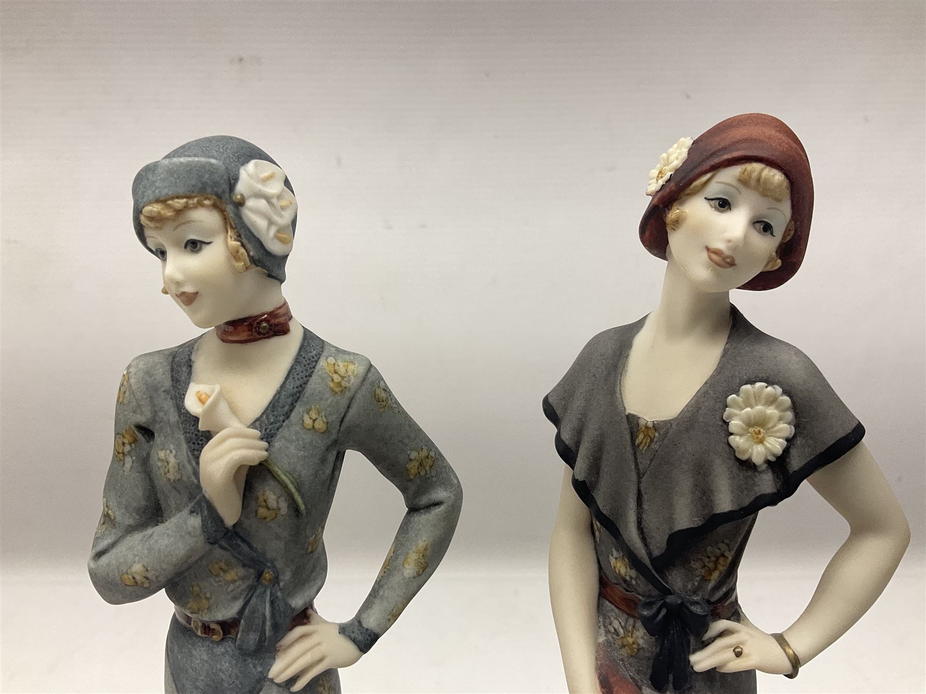 Set of four Giuseppe Armani Florence figures, Iris, Rose, Lily and Daisy, each modelled as ladies in 1920s dress amongst flowers, with names and signature inscribed and upon mahogany base, H23cm