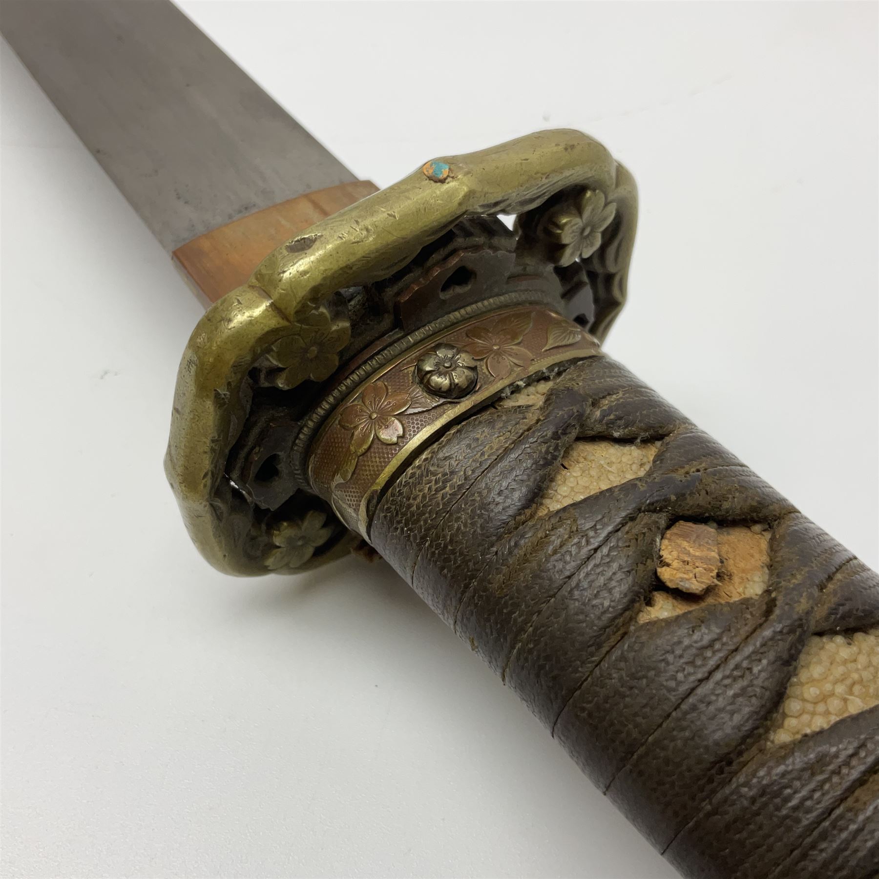 WW2 Japanese Army officer's shin gunto/katana sword with 68.5cm steel single edged blade, foliate cast brass tsuba, bound fish-skin grip with brass mounts, inscribed marks to both sides of tang; in lacquered wooden scabbard with brass mounts and locking button L97cm overall