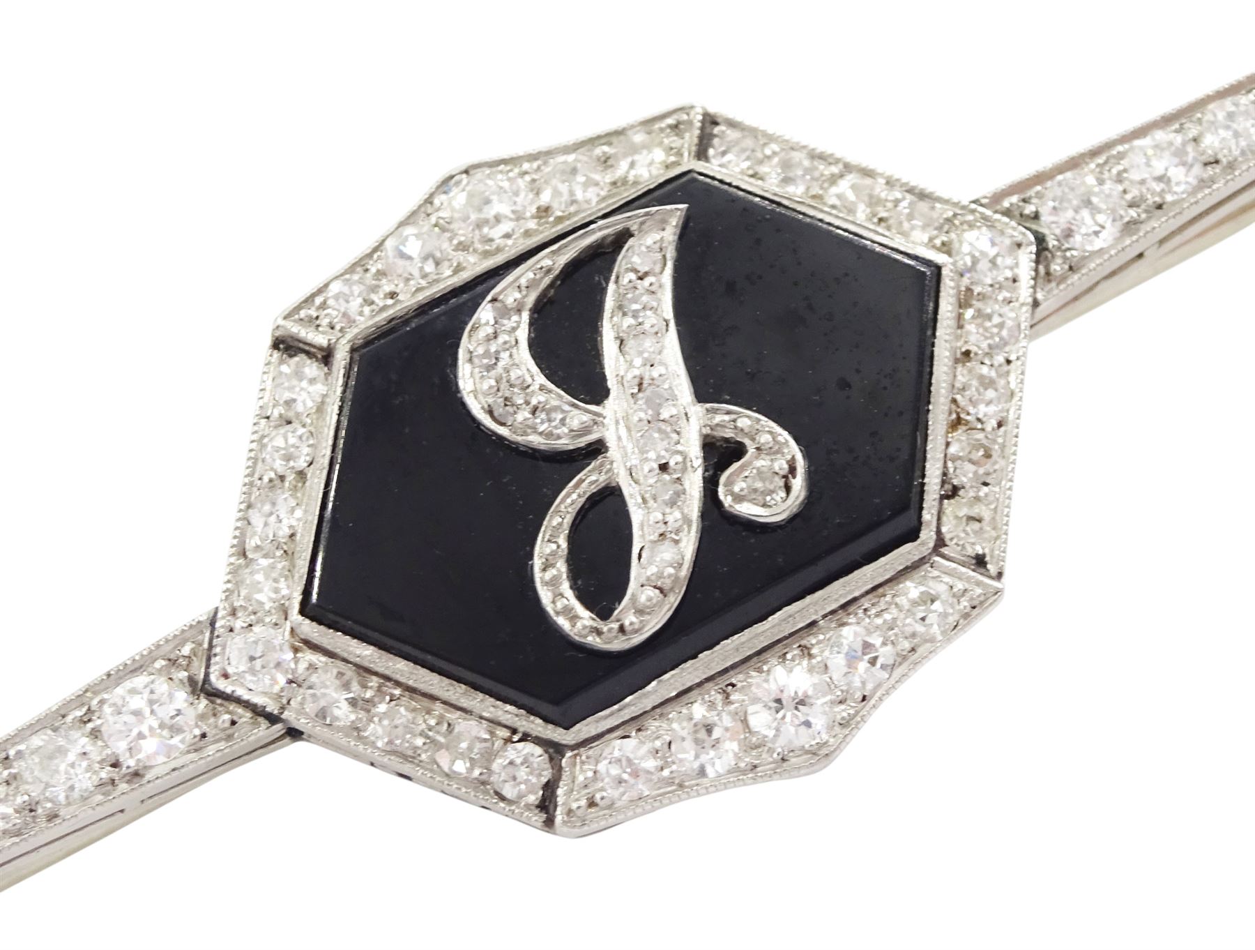 Early 20th century platinum black onyx and diamond initial brooch, single hexagon shaped black onyx with applied diamond set J, with a milgrain set, old cut diamond surround and bars, total diamond weight approx 0.95 carat