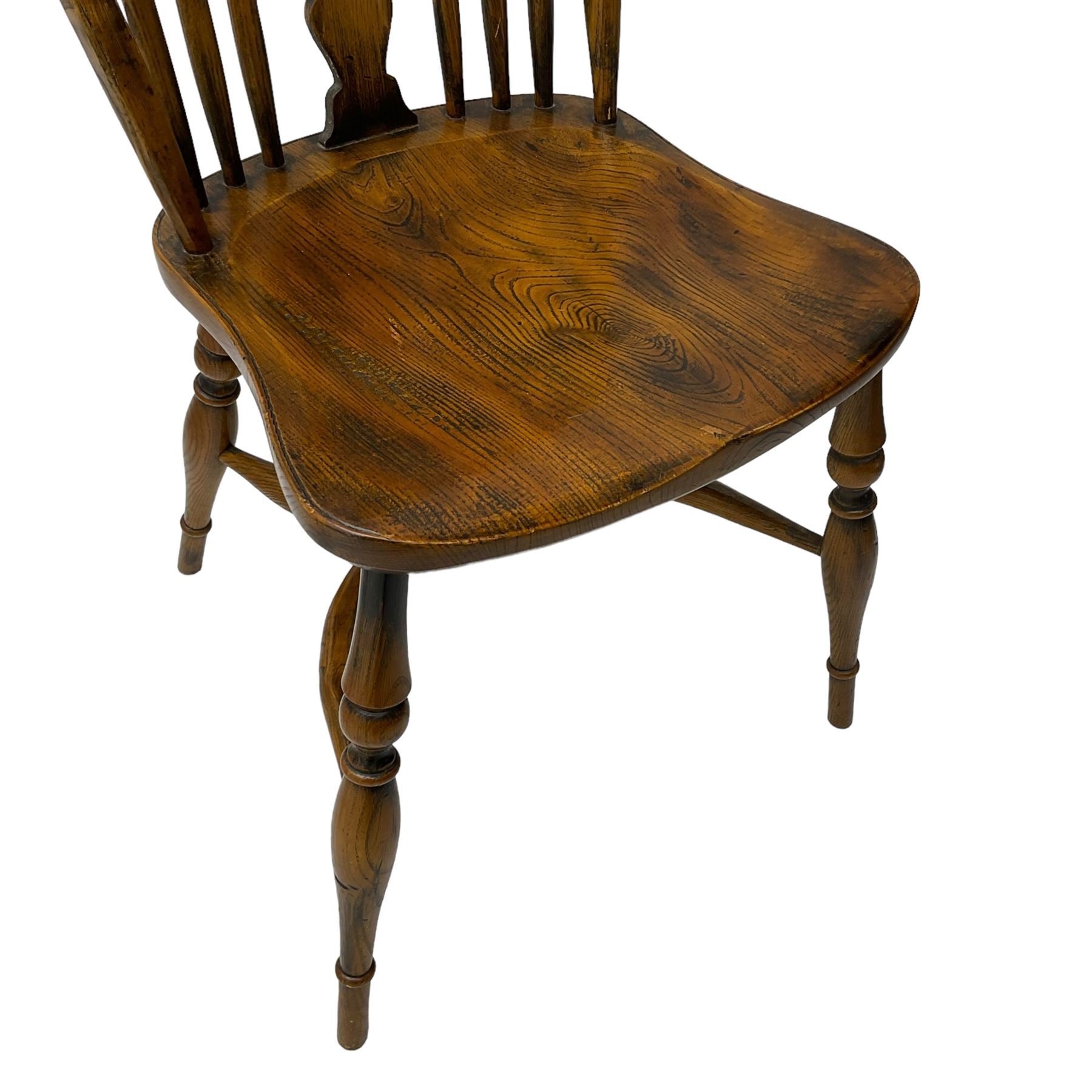 Set of four elm Windsor dining chairs, high hoop and stick back with shaped pierced splat, over shaped saddle seat, raised on ring turned supports joined by crinoline stretcher