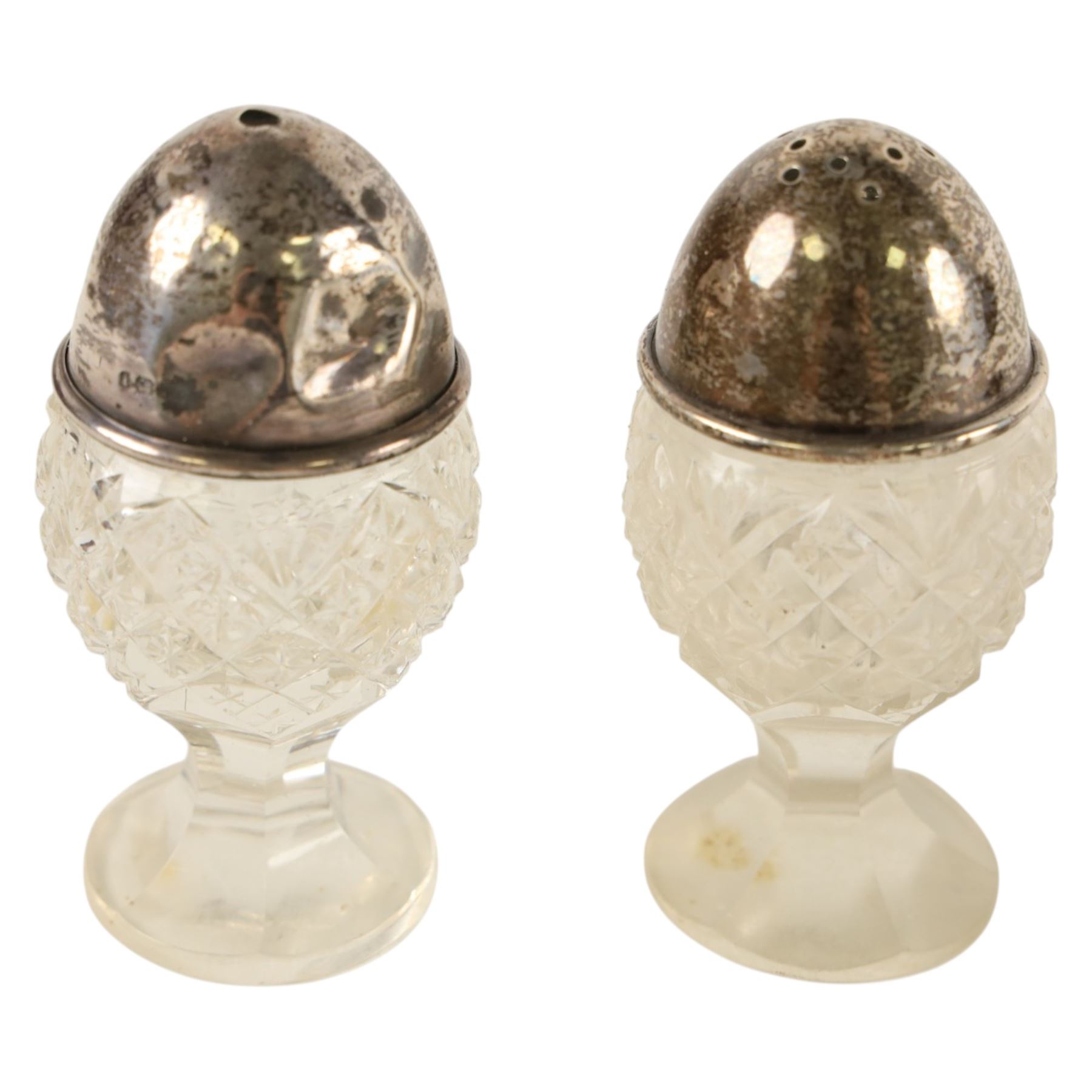 George III silver open salt with embossed floral decoration and a pair of cut glass cruets with silver lids, all hallmarked