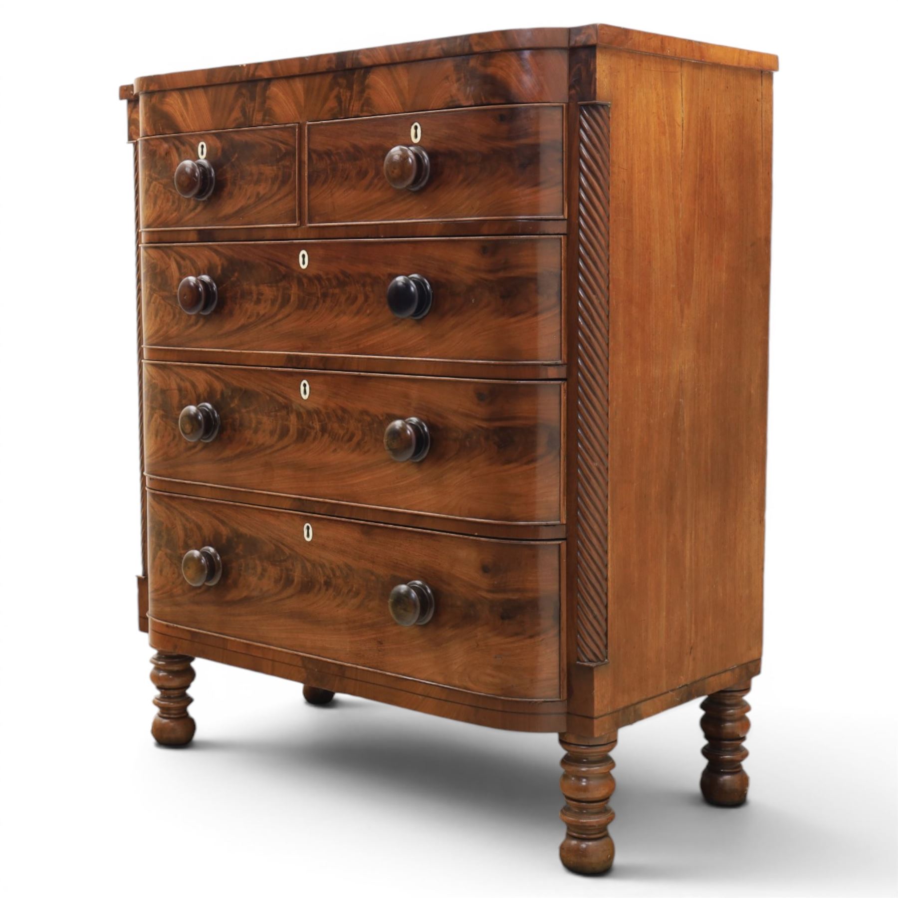Victorian mahogany bow fronted chest, fitted with two short and three long drawers, flame mahogany front, bone escutcheons and turned wooden handles, quarter barley twist columns, raised on turned supports