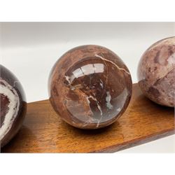 Set of three marble spheres on a elongated octagonal wooden base, H12cm