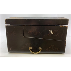  A 20th century Chinese black lacquer and gilt detailed writing box, decorated with figures, pagodas and cranes amidst a mountainous landscape, the hinged cover opening to reveal a compartmented interior and fold out baize lined slope, H20cm L46.5cm D31.5cm.   
