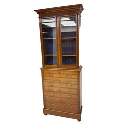 Edwardian walnut bookcase on chest, shallow form, two glazed doors above four drawers, plinth base on turned feet