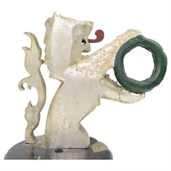 20th century carved silvered wood crest of a lion holding a wreath, possibly a horse tether, on circular wooden plinth, H37cm 