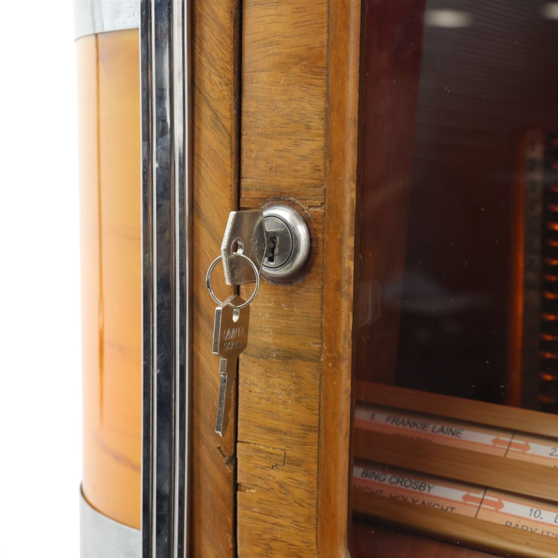 Rudolf Wurlitzer Company - Model 616 'Simplex' 1937 jukebox, figured walnut veneered cabinet with illuminated red and amber side panels enclosed by chromed uprights, glazed upper record compartment, cast Art Deco speaker grille, coin-operated push-button selection panel with circular title index, raised on a moulded base