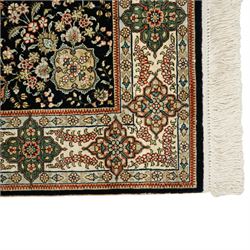 Persian-inspired Qom-style silk rug, deep indigo ground, profusely decorated with foliate motifs and a central medallion, with cotton fringe ends 