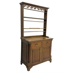 19th century and later oak dresser, moulding cornice a pierced and shaped frieze, over two open plate shelves above a base fitted with two drawers with brass swan neck handles, over panelled twin cupboard with single shelf, cantered corners on bracket feet