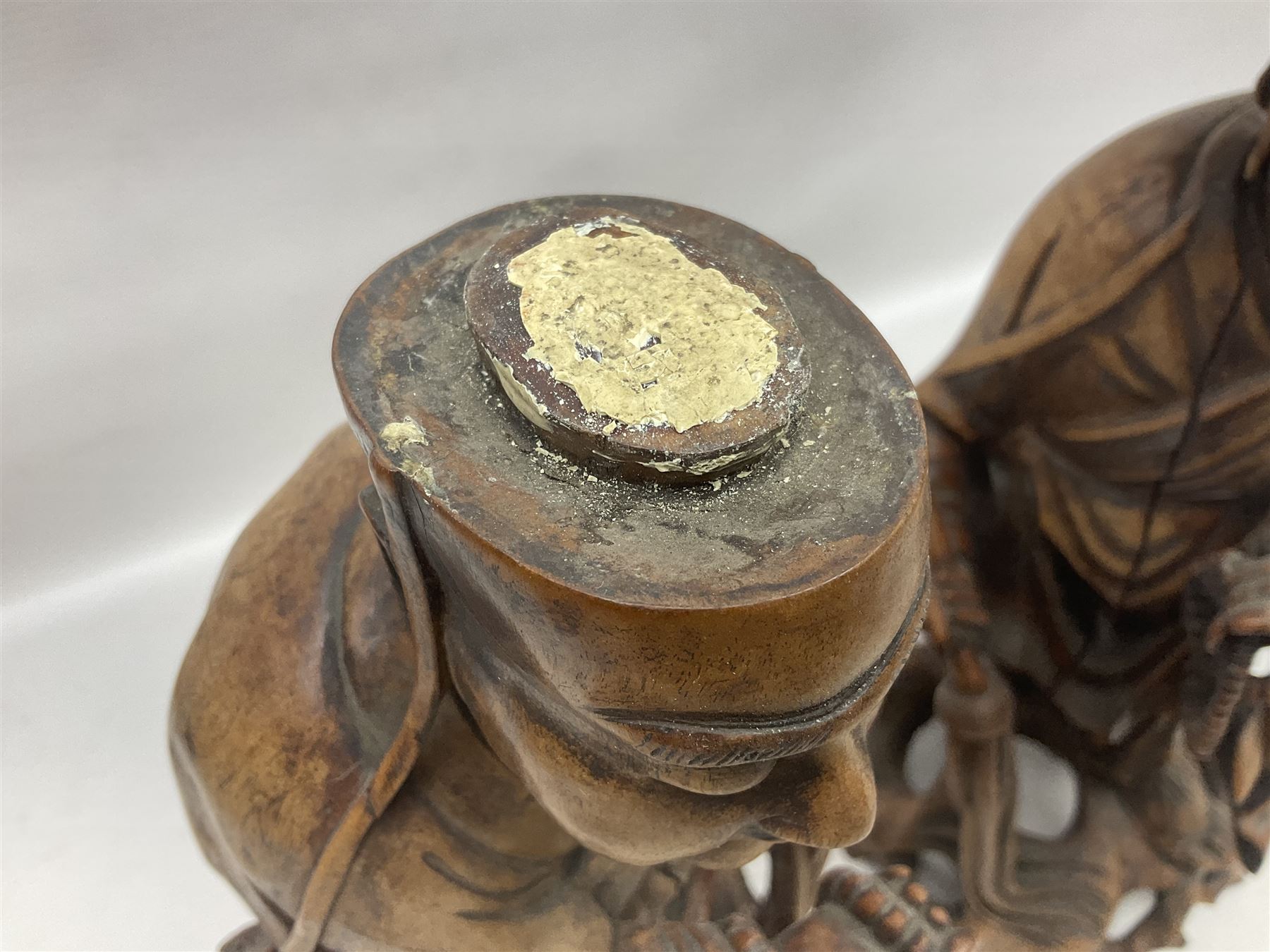 Pair of Japanese carved wooden figures, modelled as merchants in traditional dress, upon pierced naturalistic bases, tallest H39cm