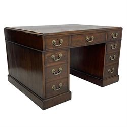 George III mahogany twin pedestal partner's desk, moulded rectangular caddy top with tooled leather inset, one side fitted with nine drawers and the opposing side fitted with single drawer, two false drawers and two panelled cupboards, ornate cast gilt metal handles and handle plates, on plinth base