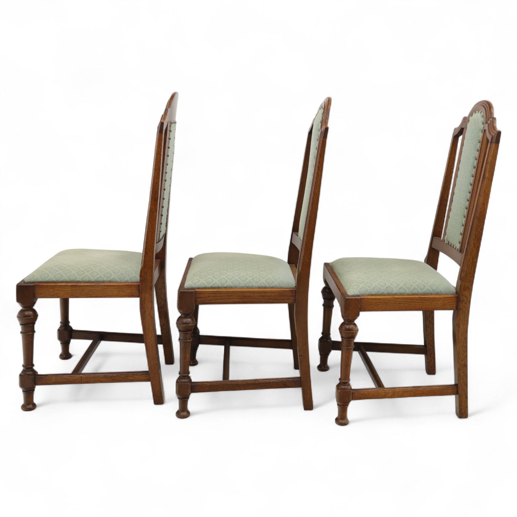 Victorian mahogany extending dining table, rectangular top with chamfered corners above a plain frieze raised on turned reeded legs with castors and two additional leaves, 197cm fully extended, and a set of six early 20th century oak upholstered chairs with drop-in seats, arched panelled back splat and close studded border on turned front legs joined by stretchers, 47x41x109cm 