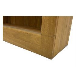 Contemporary light oak open bookcase, rectangular form with projecting top, fitted with five adjustable shelves, on a straight plinth base