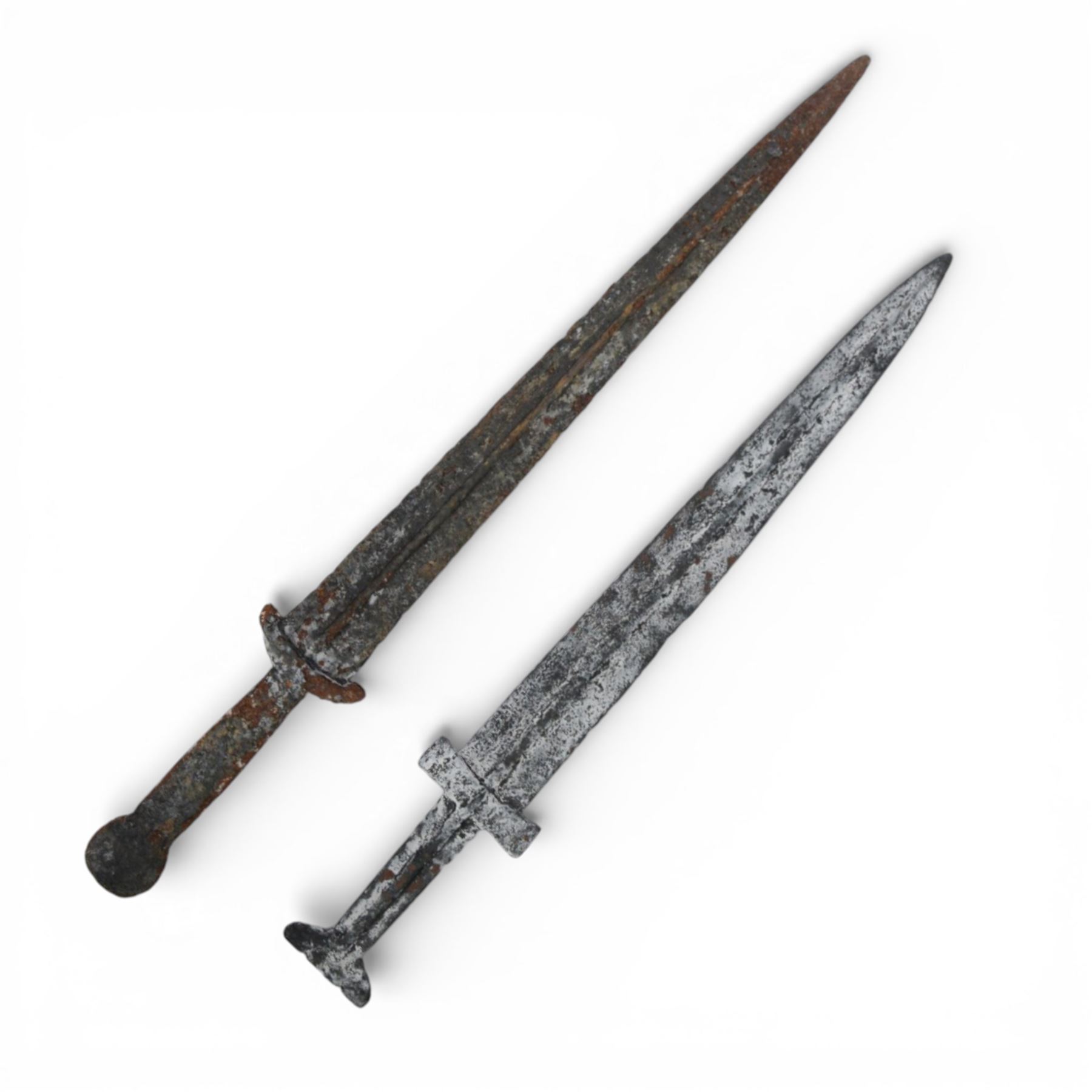 13th-6th century BC, two daggers of triangular shape with shallow fuller tapering to a pointed tip and raised midrib, short straight quillons, largest L55cm