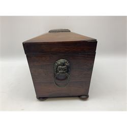 Early 19th century rosewood tea caddy, of sarcophagus form with twin lion mask ring handles, upon four compressed bun feet, the hinged cover opening to reveal a central recess for mixing bowl (now lacking), and two removable compartments