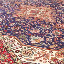 North West Persian carpet, the indigo field centred by a large terracotta and ivory medallion with matching pendants, decorated throughout with stylised palmettes, flowerheads and branching foliage, ivory geometric floral spandrels, enclosed by a red palmette border and narrow patterned guard bands